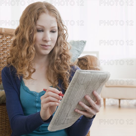 Woman reading ads in paper