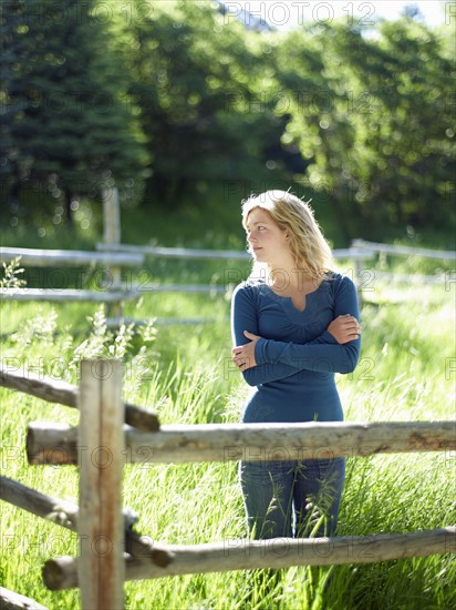 Young woman behind fence