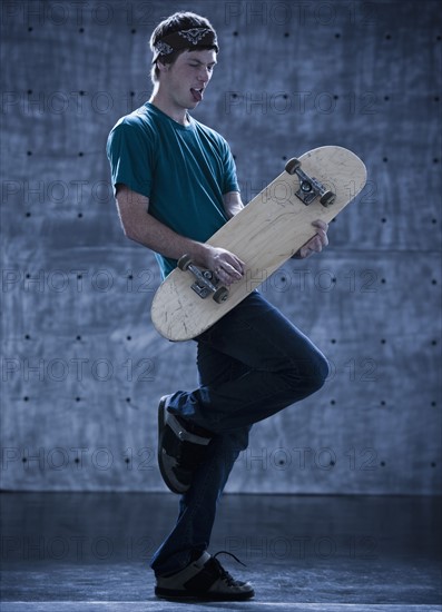 Male skateboarder playing air guitar