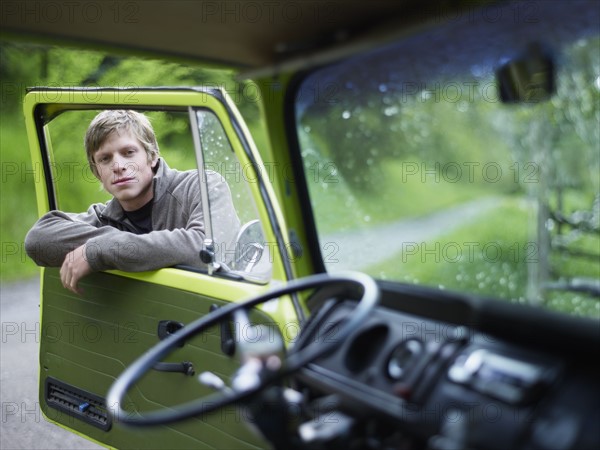 Young man hanging on door