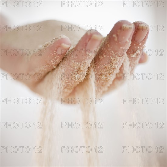 Sand grains falling through hand.