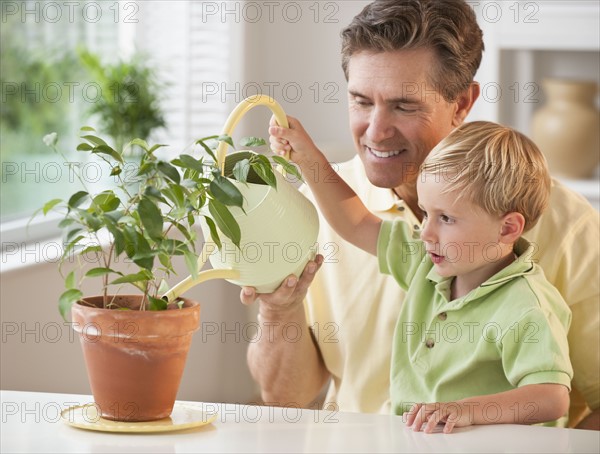 Father and child watering flowers.