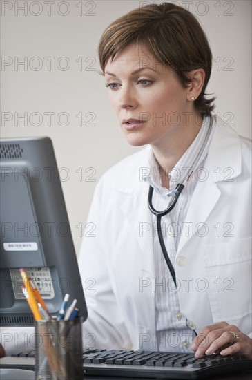 Female doctor working on laptop.