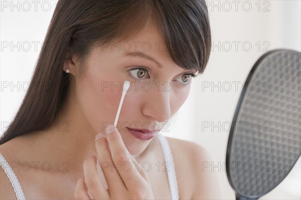 Woman applying makeup.