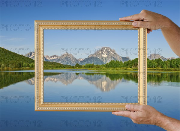 Picture frame held up to scenic view.