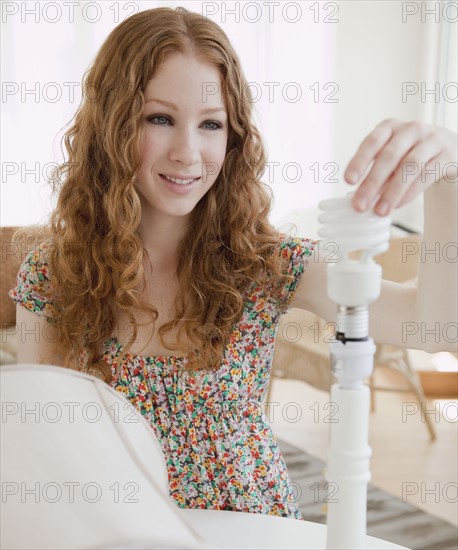 Woman screwing in lightbulb