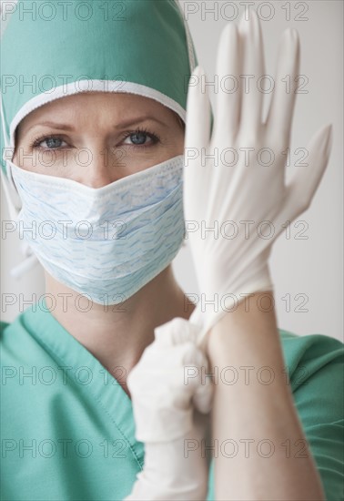 Female doctor putting on gloves.