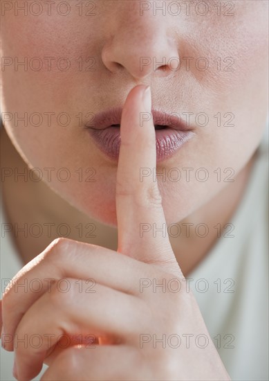 Woman gesturing to be quiet.
