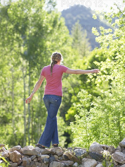 Woman walking on stone barrier