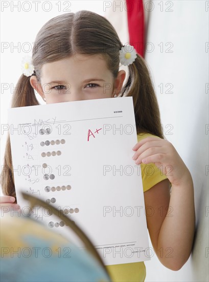 Child holding up grades