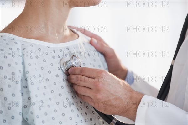 Doctor checking patient with stethoscope.