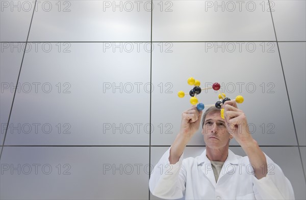 Reseacher holding molecular model.