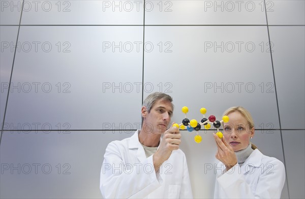 Reseachers holding molecular model.