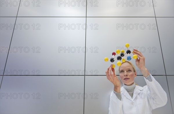 Reeacher holding molecular model.