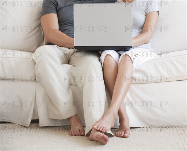 Couple on sofa with laptop.