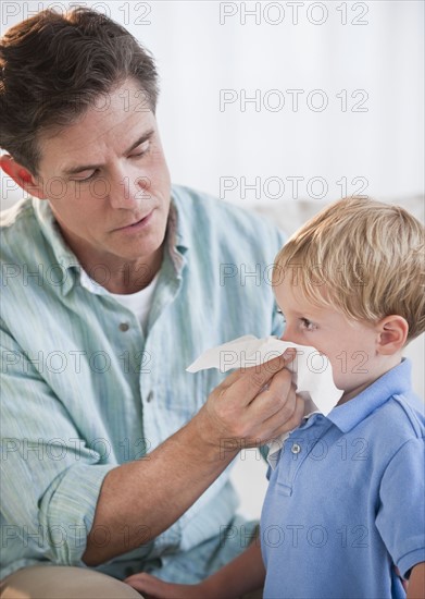 Father wiping child's nose.