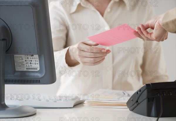 Hand passing note to office worker.