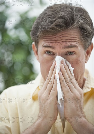 Man blowing nose.