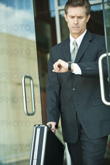 Businessman looking at watch.