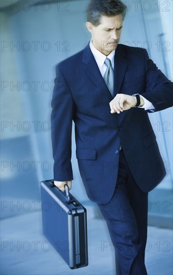 Businessman looking at watch.