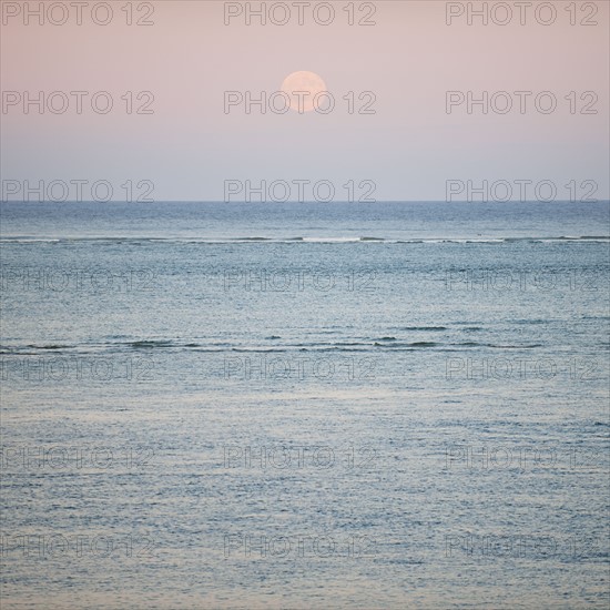 Moonrise over ocean.