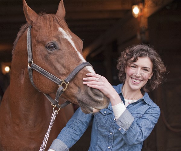 Woman holding horse.