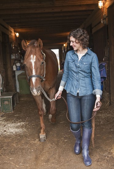 Woman leading horse.