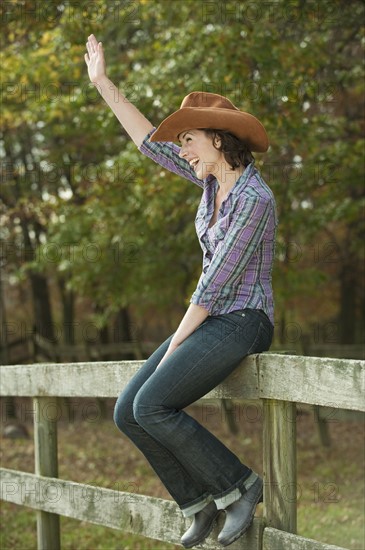 Woman sitting on fence.