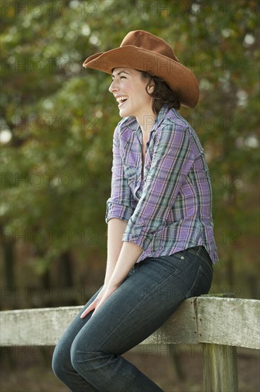 Woman sitting on fence.