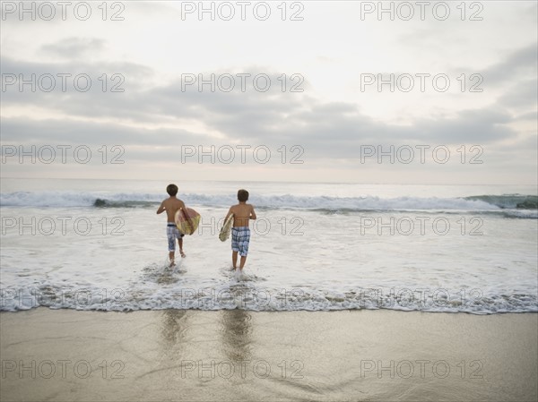 Boys running in surf