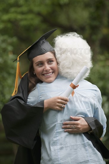 Graduate hugs elderly woman