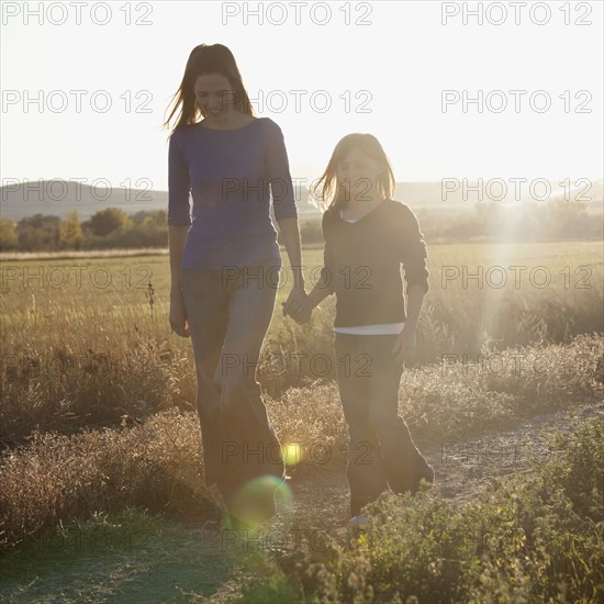 Young girl peaking out from behind grass