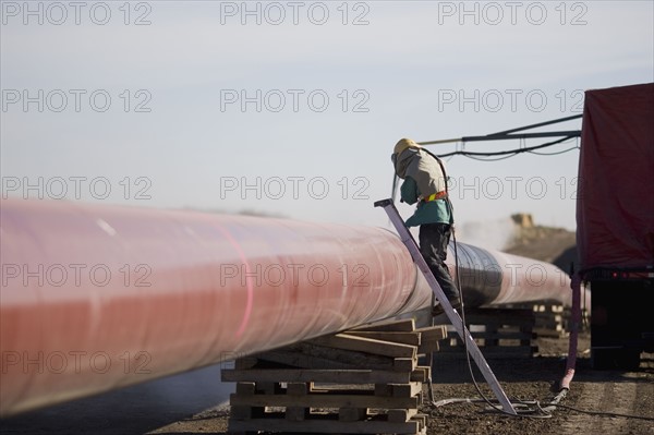 Construction worker cleaning pipleline