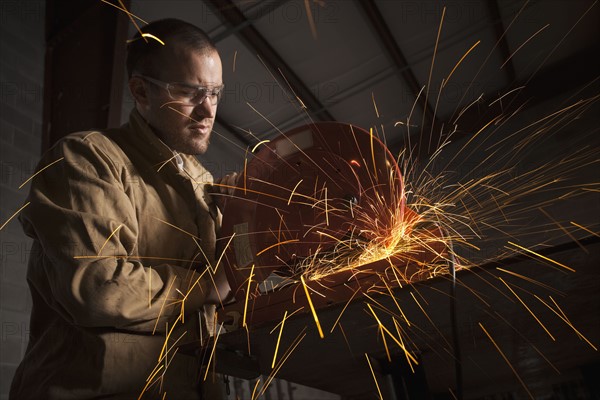 Steel grinder working in metal shop