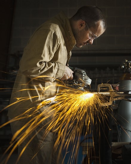 Steel grinder working in metal shop