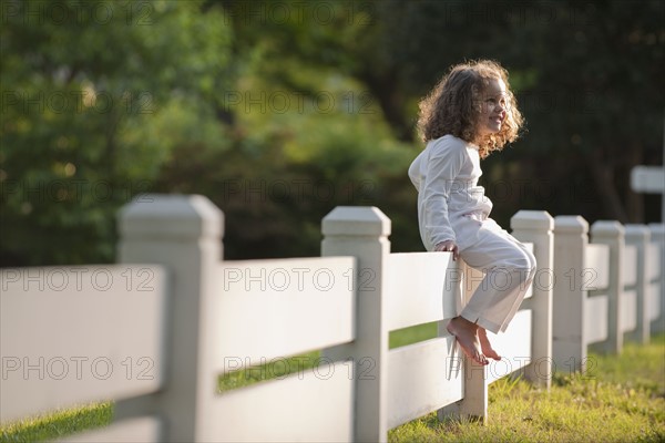 Girl sitting on fence