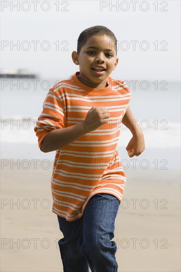 Young boy running on beach