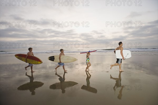 Family carrying surfboards