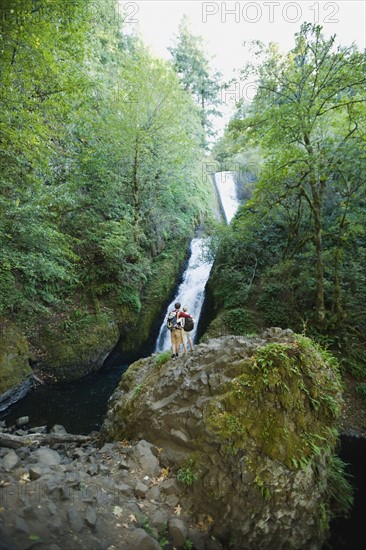 Hikers in front of waterfall