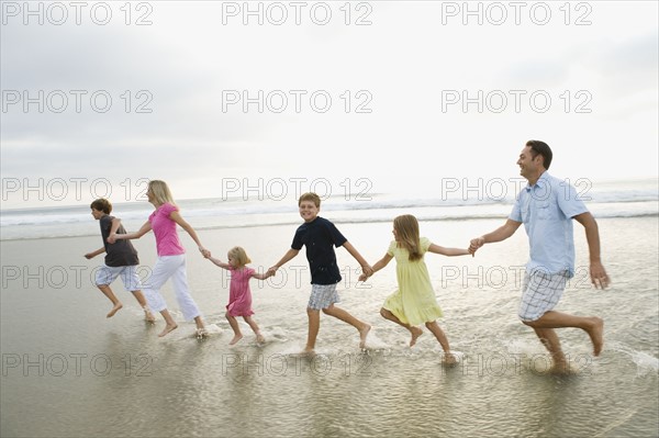 Family holding hands in ocean