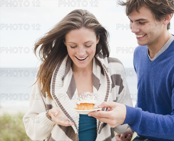 Man giving woman cupcake