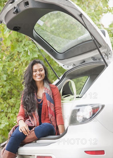 Woman sitting in trunk of car