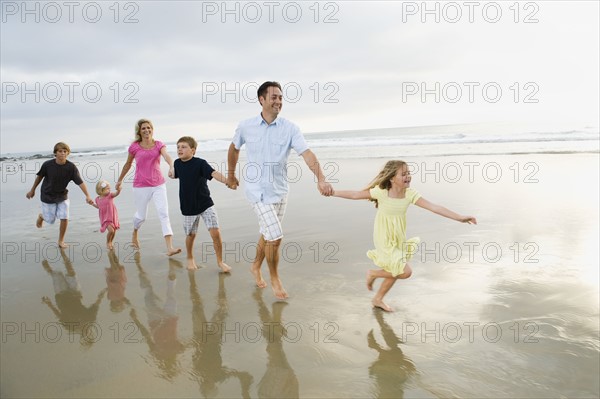 Family holding hands in ocean