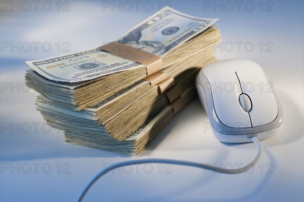 Computer mouse beside money.