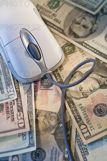 Computer mouse on top of money.