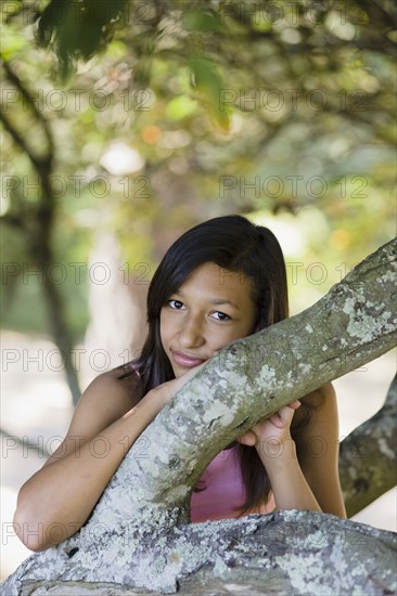 Girl leaning on tree