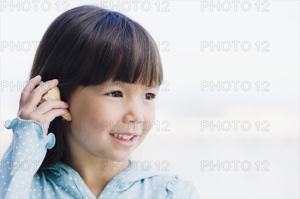 Young girl holding seashell