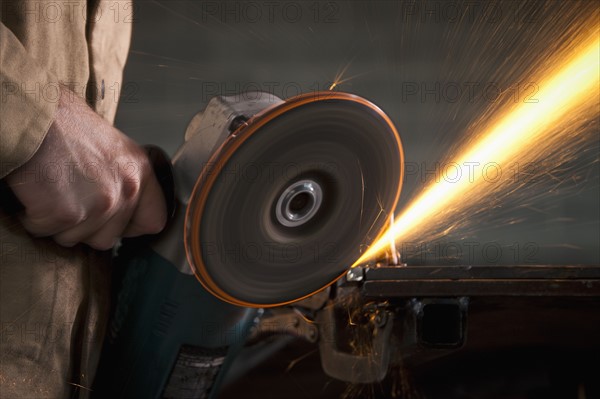 Steel grinder working in metal shop