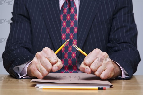 Man breaking pencil