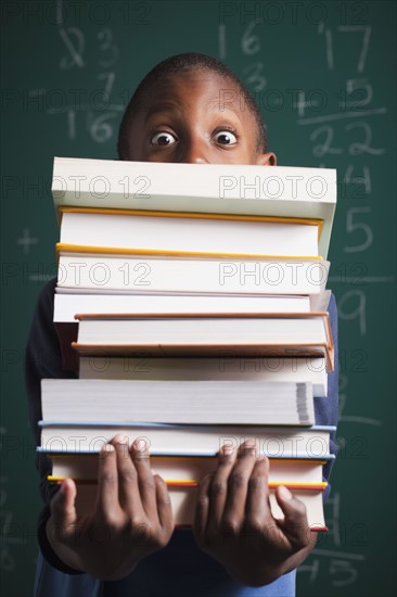 Boy holding stack of books